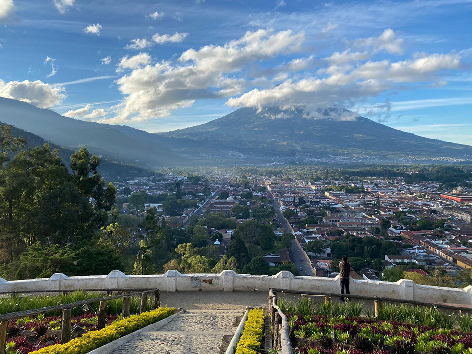 The image captures a picturesque view of a city with a prominent mountain in the background, under a clear sky.