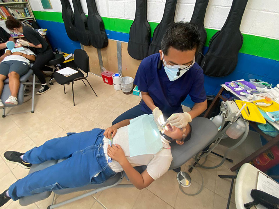 A dental professional assisting a patient during a dental appointment.