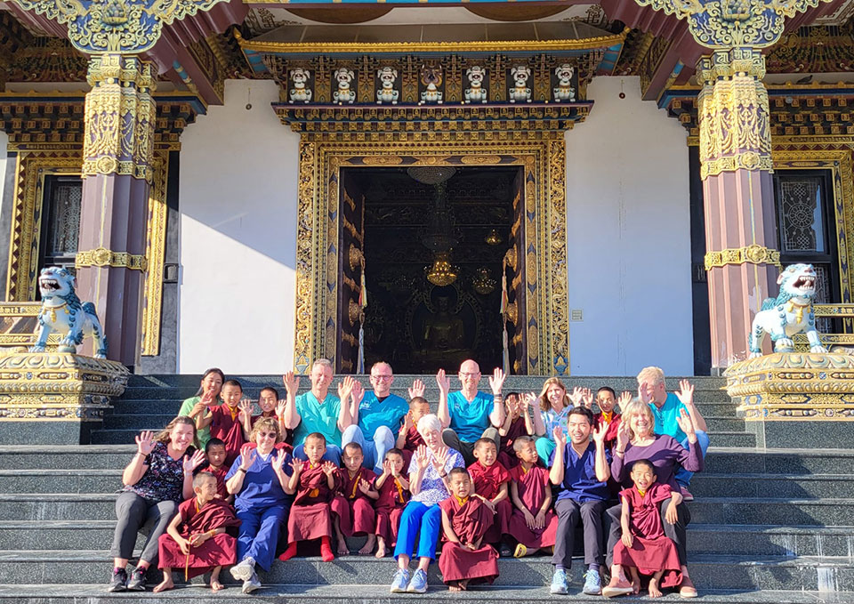 A group of people posing in front of a large, ornate building with traditional architectural features.
