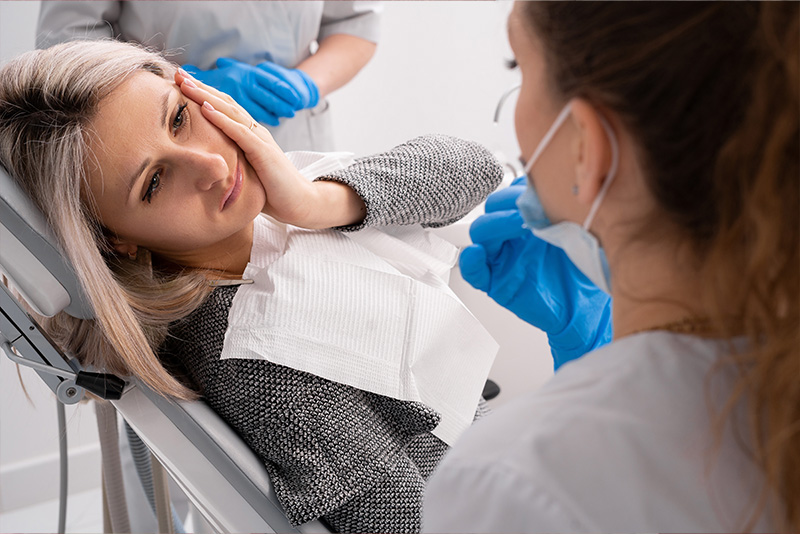 Woman receiving facial treatment in a dental chair.