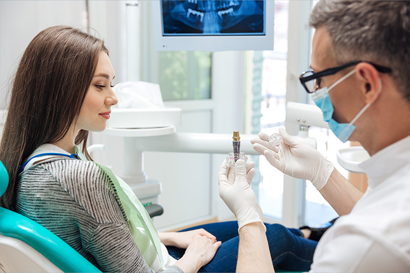 A woman receiving dental treatment, with a dentist administering a shot.