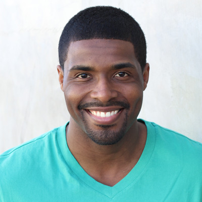 An elderly couple smiling and posing for a photo together, with the man on the left and the woman on the right.